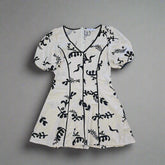 White garment with black floral patterns on a tiled floor